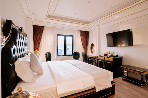 a hotel room with a bed and a television at Bao An Hotel Hung Yen in HÆ°ng YÃªn