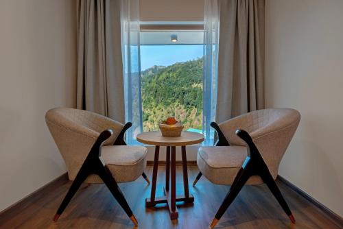 two chairs and a table in front of a window at Sterling Nainital in Nainital