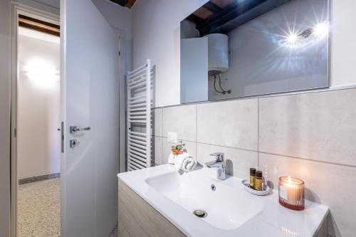 a white bathroom with a sink and a mirror at La Ripadoro Le Corti di Rivalto in Rivalto