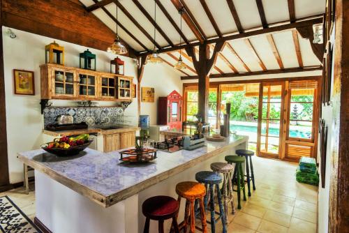 a kitchen with a large counter with stools at Lata Lama in Lovina