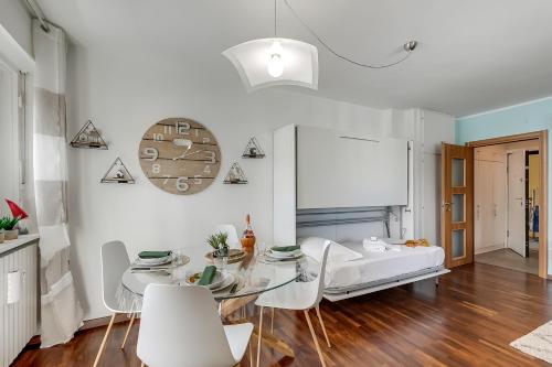 a white living room with a glass table and white chairs at Studio Blue Petit - Happy Rentals in Sestriere