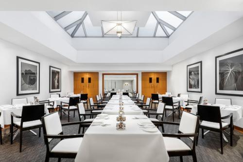 a long dining room with white tables and chairs at COMO Metropolitan London in London
