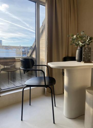 a room with a table and two chairs and a window at Edville Studio in Ghent