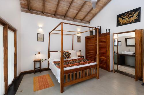 a bedroom with a canopy bed and a sink at Emel's Retreat By Tropical Magnum - Luxury Boutique Villa in Anhandigoda