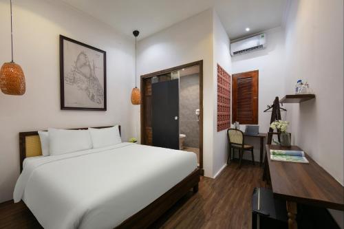 a bedroom with a white bed and a desk and a table at Hanoi Backpackers Hostel & Rooftop bar in Hanoi
