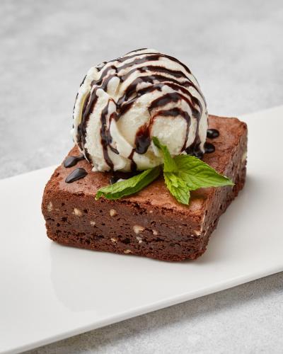 a piece of chocolate cake with ice cream on top at Yerevan Place Hotel in Yerevan