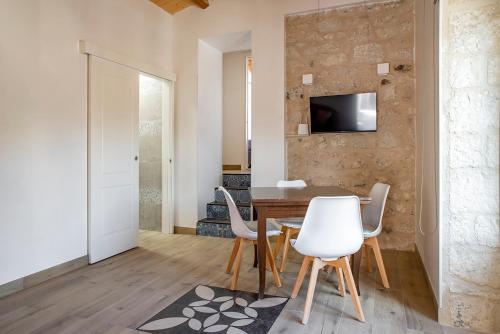 ein Esszimmer mit einem Tisch und weißen Stühlen in der Unterkunft Casa Teresa con vista in Modica