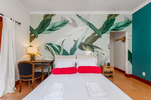 ein Schlafzimmer mit einem großen weißen Bett mit roten Kissen in der Unterkunft Villa Rancho do Sol by Trip2Portugal in Santo Estêvão