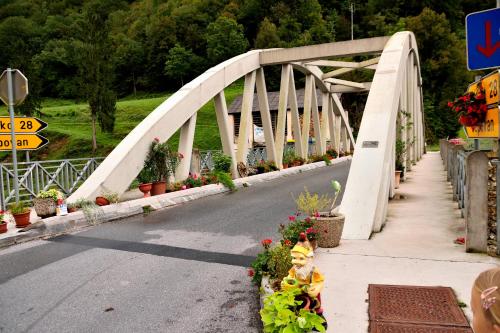 a white bridge with flowers on the side of a road at Apartment Sotočje in Dolenja Trebuša
