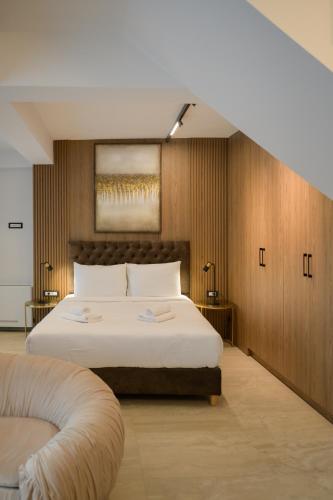 a bedroom with a large bed and a chair at Cens Platinum Luxury Suites in Ioannina