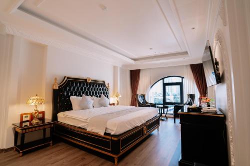 a bedroom with a large bed and a table at Bao An Hotel Hung Yen in HÆ°ng YÃªn
