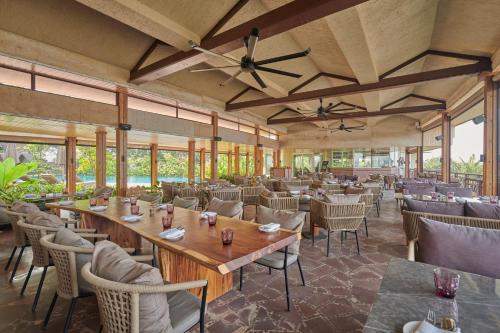 a restaurant with tables and chairs and windows at The Dukes Retreat Khandala in Lonavala