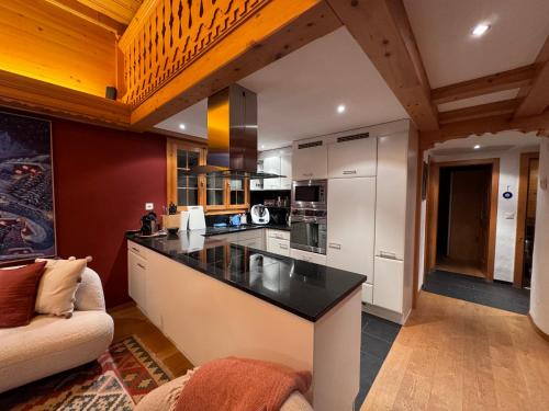 a kitchen with a black counter top in a room at Lovely 3 bedroom apartment in Schönried