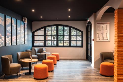 a waiting room with chairs and tables and a window at Hotel Base Camp Lodge - Albertville in Albertville