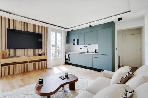 un salon avec un canapé et une table dans l'établissement PATAY - Charming Apartment, à Paris