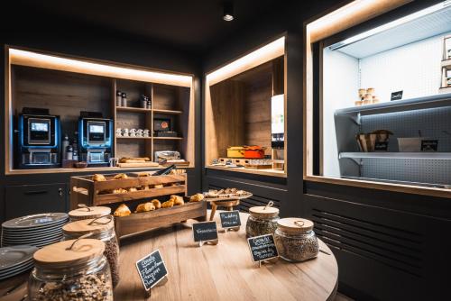 a bakery with a table and a counter with food at Hotel Base Camp Lodge - Albertville in Albertville