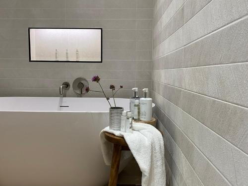 a bathroom with a white tub and a sink at Pardlestone Farm Cottages in Kilve