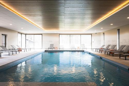 a swimming pool with lounge chairs and a swimming pool at Hotel Base Camp Lodge - Albertville in Albertville