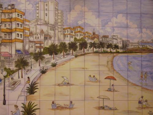 a painting of a beach with buildings and umbrellas at Hotel Macavi Playa in Rota