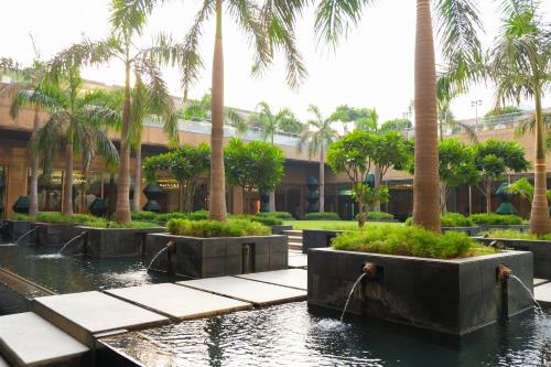 a courtyard with palm trees and a building at Crowne Plaza Today Gurugram by IHG in Gurgaon