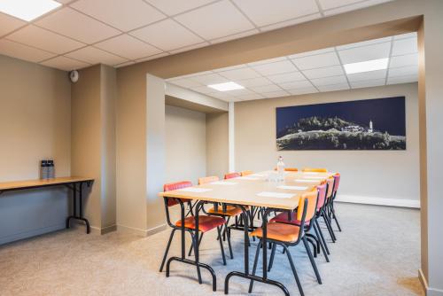 a conference room with a long table and chairs at Hotel Base Camp Lodge - Albertville in Albertville