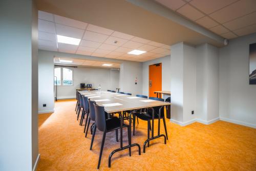a large conference room with a long table and chairs at Hotel Base Camp Lodge - Albertville in Albertville
