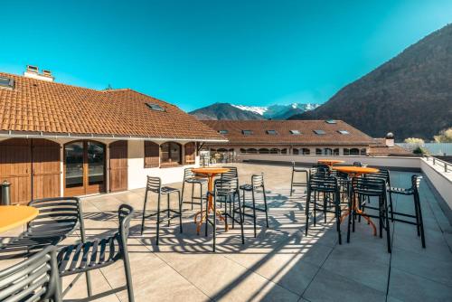a patio with chairs and tables on a roof at Hotel Base Camp Lodge - Albertville in Albertville