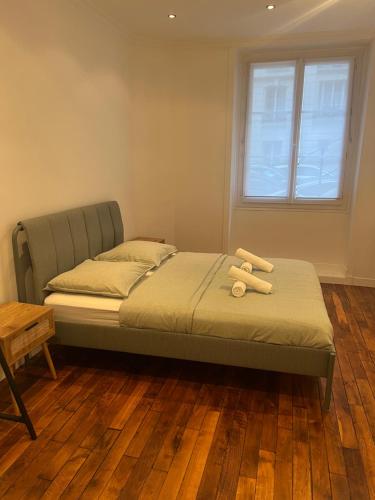 a bed with two wooden logs on it in a room at Magnifique appartement 2 chambres Paris 16e Trocadéro Tour Eiffel in Paris