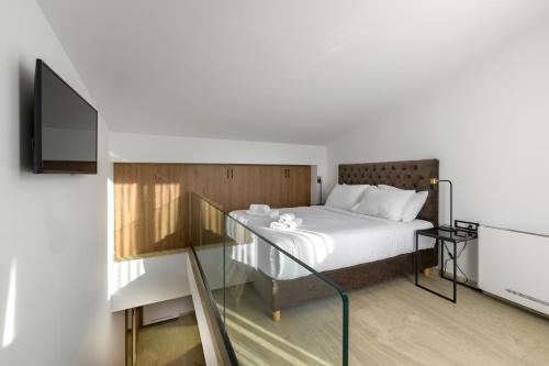 a bedroom with a bed and a tv on a wall at Cens Platinum Luxury Suites in Ioannina
