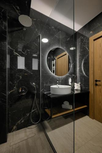 a bathroom with a sink and a mirror at Cens Platinum Luxury Suites in Ioannina