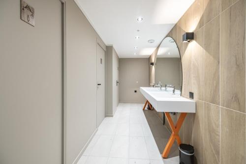 a bathroom with a sink and a mirror at Hotel Base Camp Lodge - Albertville in Albertville