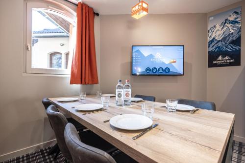 a conference room with a table with chairs and a tv at Hotel Base Camp Lodge - Albertville in Albertville
