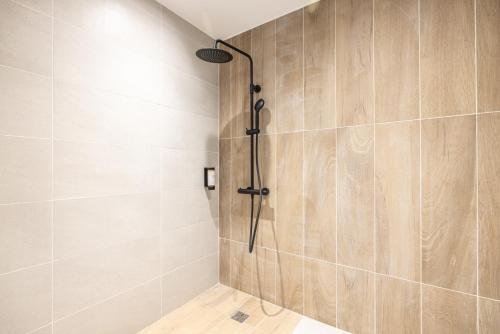 a shower in a bathroom with wooden walls and a shower at Hotel Base Camp Lodge - Albertville in Albertville