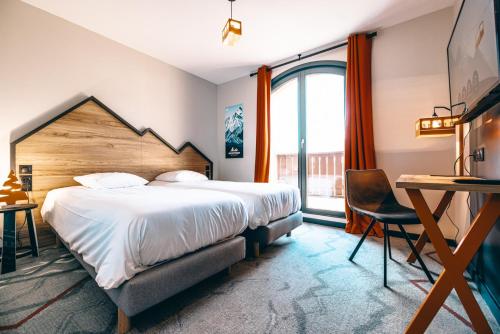 a hotel room with a large bed and a desk at Hotel Base Camp Lodge - Albertville in Albertville