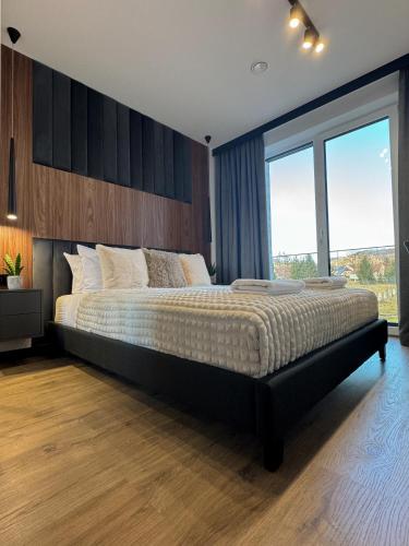 a bedroom with a large bed and a large window at Dom Neuhaus in Jeżów Sudecki