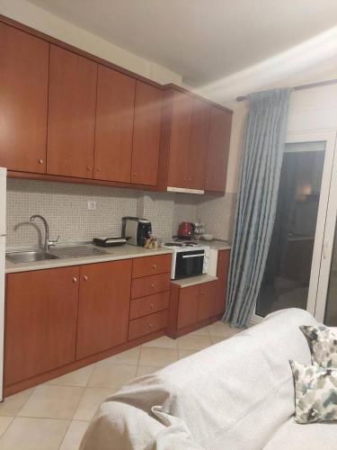 a kitchen with wooden cabinets and a sink and a bed at Κλινάρι in Xanthi