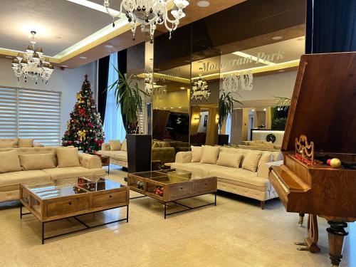 a living room with a christmas tree and a piano at Hotel Monogram Park in Ruma