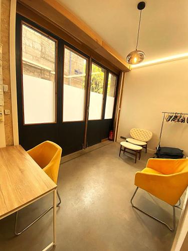 une chambre avec des chaises, une table et des fenêtres dans l'établissement Appartement cosy avec jardin terrasse et bureau séparé, à Bordeaux