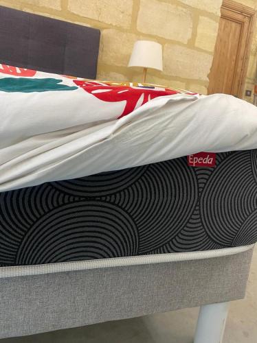 - un lit avec une couette dans l'établissement Appartement cosy avec jardin terrasse et bureau séparé, à Bordeaux