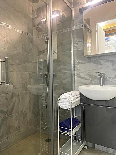 une salle de bain avec un lavabo et une douche en verre dans l'établissement Appartement cosy avec jardin terrasse et bureau séparé, à Bordeaux