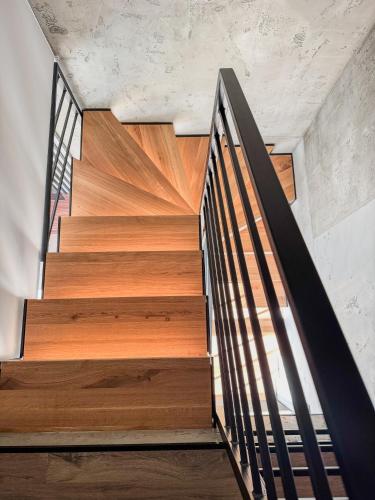 a wooden staircase with a metal railing in a house at Dom Neuhaus in Jeżów Sudecki