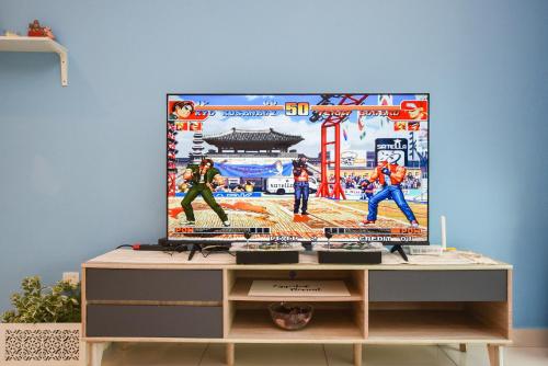 a tv screen on top of a wooden cabinet at Midvalley Southkey Mosaic Suite by Nest Home in Johor Bahru