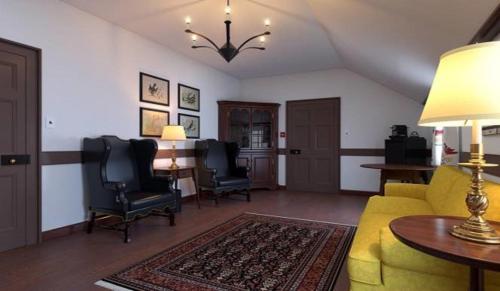 a living room with a yellow couch and chairs at Colonial Houses, an official Colonial Williamsburg Hotel in Williamsburg