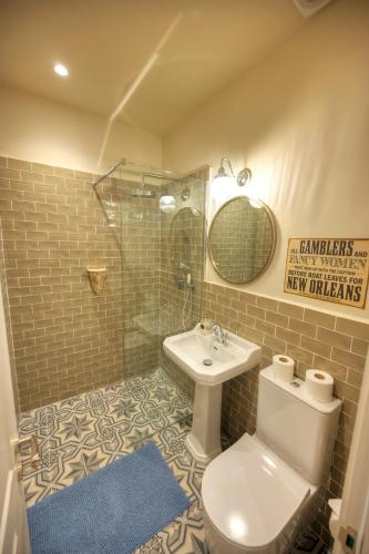 a bathroom with a toilet and a sink and a mirror at Luxury & stylish 4bedroom, Valletta centre LDEM1-1 in Valletta