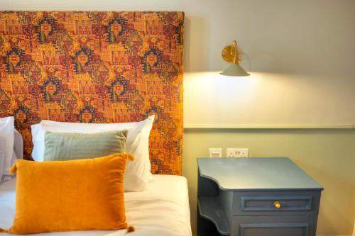 a bedroom with a bed with a blue nightstand and a wall at Luxury & stylish 4bedroom, Valletta centre LDEM1-1 in Valletta