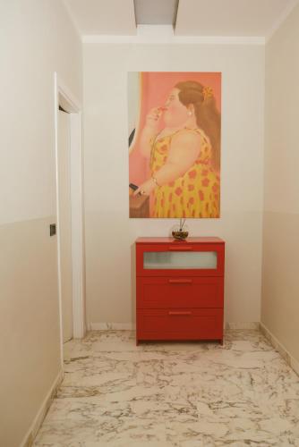 a red dresser in a room with a painting on the wall at B&B Boteroom in Cassino