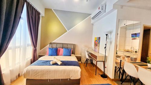 - une chambre avec un lit doté d'oreillers bleus et d'un bureau dans l'établissement Gothca Imperium Residence Kuantan Studio Seaview, à Kuantan