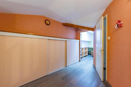 an orange room with a closet and a clock on the wall at Le bel Oasis parking facile in Balma