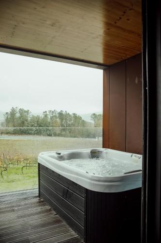 a large bath tub in a room with a window at Quinta das Areias - Solar da Pena in Braga