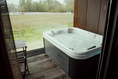 a bath tub in a room with a view of a field at Quinta das Areias - Solar da Pena in Braga